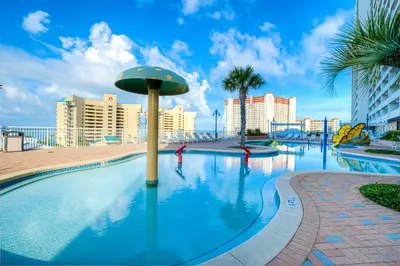 a large swimming pool with palm trees and buildings at Laketown Wharf 1135 NEW in Panama City Beach