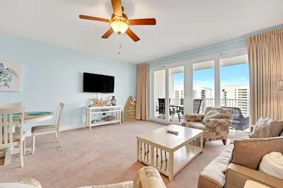 a living room with a couch and a ceiling fan at The Blue Turtle Laketown in Panama City Beach
