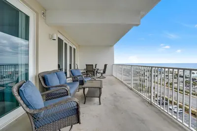 a balcony with chairs and a view of the ocean at The Blue Turtle Laketown in Panama City Beach