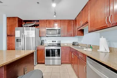 a kitchen with wooden cabinets and stainless steel appliances at The Blue Turtle Laketown in Panama City Beach