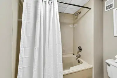a shower with a white shower curtain in a bathroom at Edgewater Tower 3-1104 in Panama City Beach