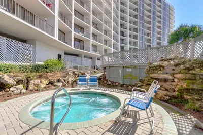 a swimming pool with chairs and a building at Edgewater Tower 3-1104 in Panama City Beach