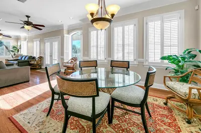 a dining room with a glass table and chairs at Sunset Breeze in Panama City Beach