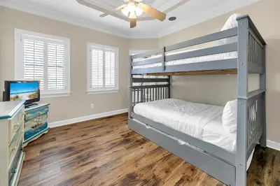 a bedroom with two bunk beds and a television at Sunset Breeze in Panama City Beach