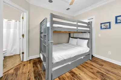 a bedroom with a bunk bed with white sheets at Sunset Breeze in Panama City Beach