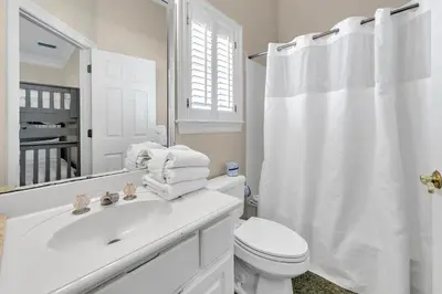 a white bathroom with a toilet and a sink at Sunset Breeze in Panama City Beach