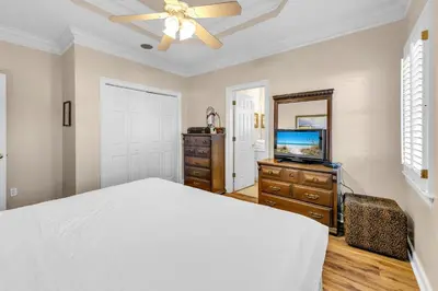 a bedroom with a bed and a flat screen tv at Sunset Breeze in Panama City Beach