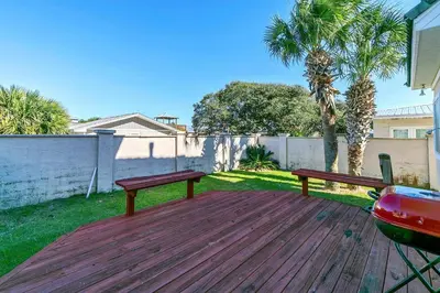 two benches sitting on a wooden deck in a yard at Sunset Breeze in Panama City Beach