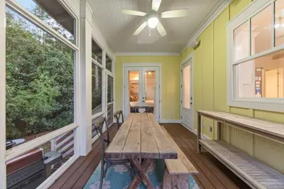 a porch with a wooden table and windows at 30A | Pool | Sunnyside Up | Walk to Beach| Golf Cart | Seagrove in Santa Rosa Beach