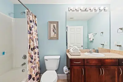 a bathroom with a toilet and a sink and a mirror at Blue Turtle at Laketown in Panama City Beach