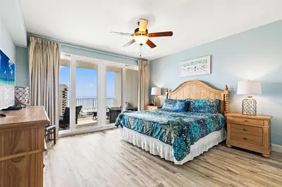 a bedroom with a bed with a view of the ocean at Blue Turtle at Laketown in Panama City Beach