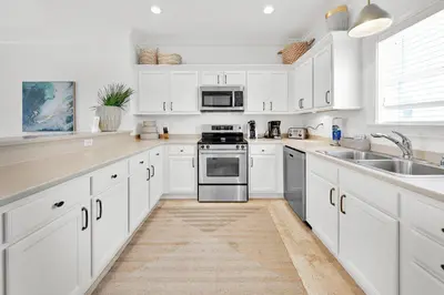 a white kitchen with white cabinets and a sink at Legacy 502 - Abalone in Santa Rosa Beach