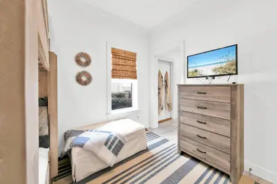 a bedroom with a bed and a dresser with a television at Legacy 502 - Abalone in Santa Rosa Beach