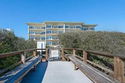 a wooden boardwalk leading to a building on the beach at Legacy 502 - Abalone in Santa Rosa Beach