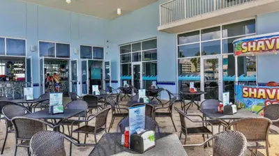 a restaurant with tables and chairs in front of a building at Beachfront Retreat! Family Friendly 1BD Getaway! by Dolce Vita Getaways PCB! in Panama City Beach