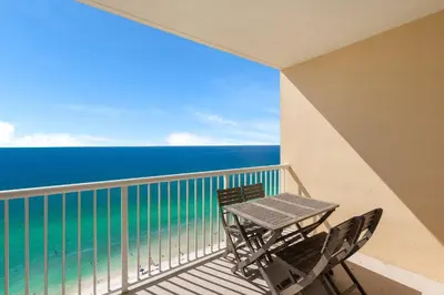 a balcony with a table and chairs and the ocean at Beachfront Retreat! Family Friendly 1BD Getaway! by Dolce Vita Getaways PCB! in Panama City Beach
