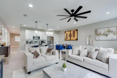 a living room with two couches and a kitchen at Luxury Retreat near St. Andrews in Panama City Beach