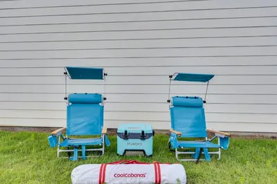 two blue chairs sitting in the grass next to a house at Luxury Retreat near St. Andrews in Panama City Beach