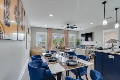 a dining room and living room with a table and chairs at Luxury Retreat near St. Andrews in Panama City Beach