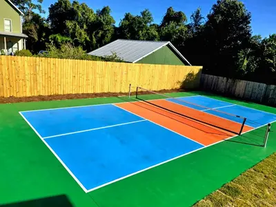 a tennis court in a backyard at Luxury Retreat near St. Andrews in Panama City Beach