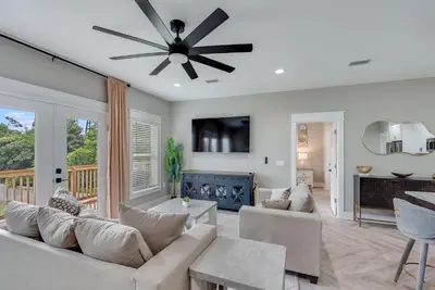 a living room with a couch and a ceiling fan at Luxury Retreat near St. Andrews in Panama City Beach