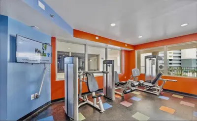 a gym with two treadmills and two ellipticals at Beachfront Retreat! Spacious Resort Condo with Great Views! by Dolce Vita Getaways PCB! in Panama City Beach