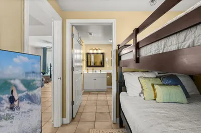 a bedroom with a bunk bed and a bathroom at Beachfront Retreat! Spacious Resort Condo with Great Views! by Dolce Vita Getaways PCB! in Panama City Beach