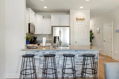 a kitchen with a counter with stools around it at Florida Knights by the Sea in Panama City Beach