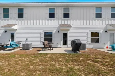 a white building with a table and chairs in front of it at Florida Knights by the Sea in Panama City Beach