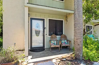 two chairs sitting on the front porch of a house at Coconut Cottage in Panama City Beach