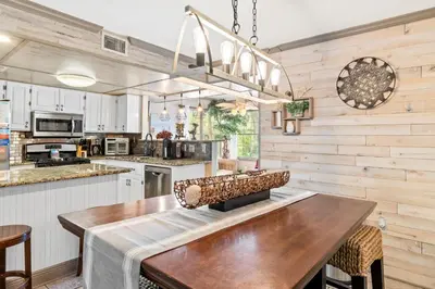 a kitchen with a large wooden table and chairs at Coconut Cottage in Panama City Beach