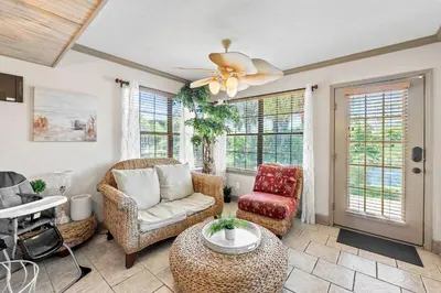 a living room with furniture and a ceiling fan at Coconut Cottage in Panama City Beach