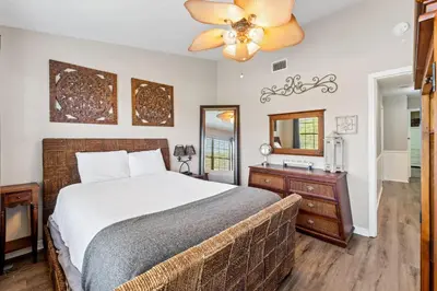 a bedroom with a bed and a dresser and a mirror at Coconut Cottage in Panama City Beach