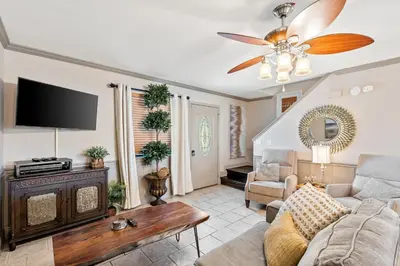 a living room with a couch and a ceiling fan at Coconut Cottage in Panama City Beach