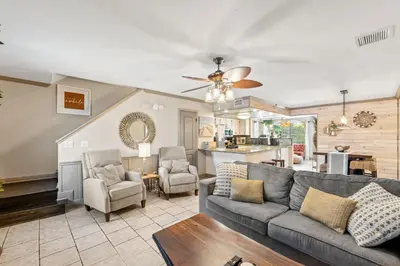 a living room with a couch and a kitchen at Coconut Cottage in Panama City Beach