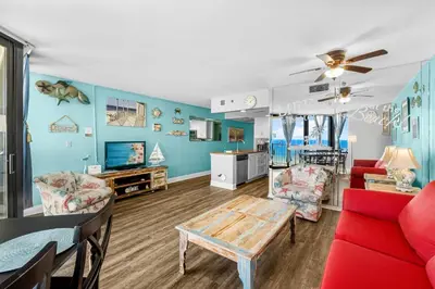 a living room with a red couch and a table at Sunbird Resort! Stunning Beach and Ocean Views! by Dolce Vita Getaways PCB in Panama City Beach