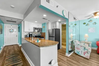 a kitchen with blue walls and a counter top at Sunbird Resort! Stunning Beach and Ocean Views! by Dolce Vita Getaways PCB in Panama City Beach