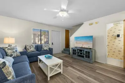 a living room with a couch and a tv at Charming Townhouse in Gulf Highland Beach Resort! Amenities Galore in Panama City Beach