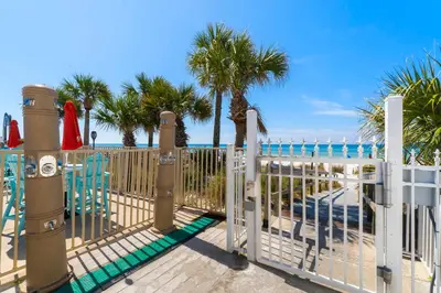 a gate at the beach with palm trees at Charming Townhouse in Gulf Highland Beach Resort! Amenities Galore in Panama City Beach