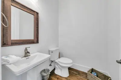 a bathroom with a sink and a toilet and a mirror at Gathering Thyme in Santa Rosa Beach