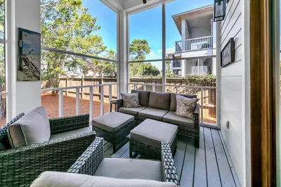 a screened porch with couches and chairs and windows at Gathering Thyme in Santa Rosa Beach