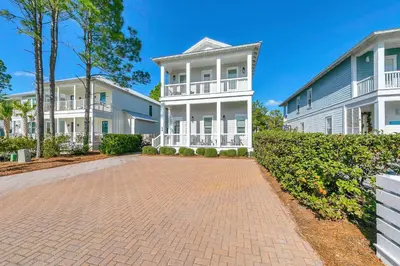 a large white house with a brick driveway at Gathering Thyme in Santa Rosa Beach