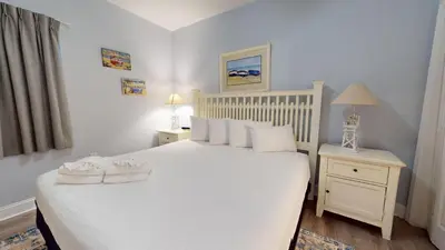 a bedroom with a white bed with white pillows at Tidewater 1616 in Panama City Beach