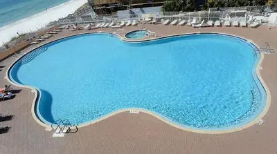 an overhead view of a swimming pool next to the beach at Tidewater 1616 in Panama City Beach