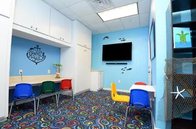 a waiting room with chairs and a flat screen tv at Tidewater 1616 in Panama City Beach