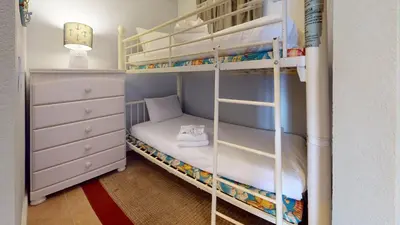 a bunk bed with a ladder in a room at Tidewater 1616 in Panama City Beach