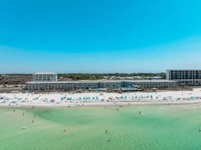 a beach with a large group of people in the water at Sandpiper Beacon Beach Resort in Panama City Beach