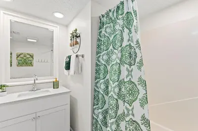 a bathroom with a shower curtain and a sink at Sandpiper Beacon Beach Resort in Panama City Beach