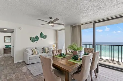 a dining room with a table and a view of the ocean at Sandpiper Beacon Beach Resort in Panama City Beach