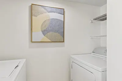 a bathroom with a washing machine and a picture on the wall at Sandpiper Beacon Beach Resort in Panama City Beach